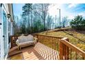Spacious wooden porch offers a serene outdoor retreat with a comfortable bench and views of the lush green yard at 4845 Midway Sand Rd, Hickory, NC 28601