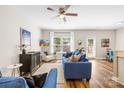 Bright living room featuring hardwood floors, a comfortable blue sofa, and a large window with natural light at 5648 Woodard St, Charlotte, NC 28269
