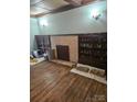 Spacious room with hardwood floors, a brick fireplace, and built-in shelving on both sides at 621 Benton St, Monroe, NC 28110