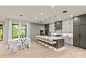 Bright eat-in kitchen featuring a long island with seating and stainless appliances with hardwood floors and modern lighting at 624 Heather Ln, Charlotte, NC 28209