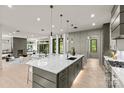 Modern kitchen featuring a large island with marble countertop and stainless steel appliances and seamlessly open to living area at 624 Heather Ln, Charlotte, NC 28209