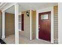 Inviting front porch featuring a brick-red door with glass accents and white columns at 6430 Matlea Ct, Charlotte, NC 28215