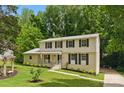 Traditional two-story home boasts a well-manicured lawn and mature trees, providing a serene and inviting curb appeal at 7016 Wannamaker Ln, Charlotte, NC 28226