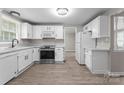 Bright kitchen with white cabinets, stainless steel appliances and light wood-look floors at 7016 Wannamaker Ln, Charlotte, NC 28226