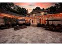 Expansive stone patio with outdoor seating, dining area, landscaped garden, and elegant lighting, ideal for entertaining at 8305 Bar Harbor Ln, Charlotte, NC 28210