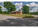 View of a brick home on a corner lot with mature trees and a well-kept lawn at 85 Sw Myrtle Sw Ave, Concord, NC 28025