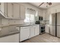 Kitchen with stainless appliances, white cabinets, and laminate flooring at 85 Sw Myrtle Sw Ave, Concord, NC 28025