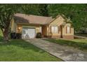 Charming yellow home with attached garage and well-maintained landscaping at 11701 Brockley Ct, Charlotte, NC 28215