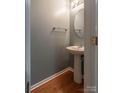 Small half bathroom featuring a pedestal sink, wood-look floors, and brushed nickel hardware at 118 Barnhardt Loop, Mooresville, NC 28117