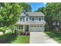 Beautiful two-story home with grey siding, mature trees, and an attached two-car garage at 1209 Leigh Ave, Charlotte, NC 28205