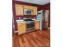 Modern kitchen with stainless steel appliances, light oak cabinets, and hardwood floors at 14343 Arbor Ridge Dr, Charlotte, NC 28273