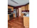 Modern kitchen with stainless steel appliances, light oak cabinets, and hardwood floors at 14343 Arbor Ridge Dr, Charlotte, NC 28273