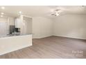 Open-concept living area with light-colored floors adjacent to a kitchen area with stainless steel appliances at 1528 Doran Ter, Richburg, SC 29729