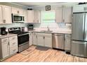 Updated kitchen with stainless steel appliances, sleek white cabinets, and stylish subway tile backsplash at 1750 Sells Rd, Salisbury, NC 28144