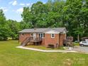 Well-kept brick home with a metal roof, multiple decks, and a spacious green lawn at 1792 Hoffman Rd, Gastonia, NC 28054