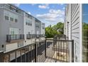 View from balcony showcasing multi-level townhomes with black railings, garages, and landscaped grounds at 2013 Clarksdale Dr # 38, Charlotte, NC 28206