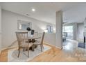 Charming dining area with wood floors, a round table, and seating for four near the living area at 2209 Sumner Green Ave # M, Charlotte, NC 28203