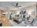 Open concept living room showcasing hardwood floors and a view into the kitchen at 2209 Sumner Green Ave # M, Charlotte, NC 28203