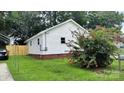 View of the back of the home showcasing the yard, fence, and a colorful flower bush at 2328 Milton Ave, Gastonia, NC 28052