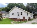 Side view of a quaint house with white siding, red brick foundation, and a small, well-kept yard at 2328 Milton Ave, Gastonia, NC 28052