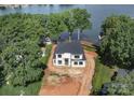 New construction features stunning views, with surrounding trees, and sits directly next to the lake at 242 Shoreline Loop, Mooresville, NC 28117