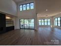Spacious living room featuring hardwood floors, fireplace, and scenic water views at 242 Shoreline Loop, Mooresville, NC 28117