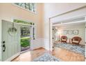 Bright entryway featuring hardwood floors, an open door, and a glimpse into a cozy sitting area at 2635 Cotton Planter Ln, Charlotte, NC 28270