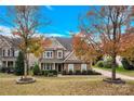 Charming two-story home with stone and wood facade, lush landscaping, and inviting front entrance at 282 Fischer Rd, Fort Mill, SC 29175