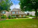 Charming two-story home featuring a well-manicured lawn and beautiful landscaping at 282 Fischer Rd, Fort Mill, SC 29175