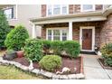 Landscaped front yard with stone edging, bushes, and walkway to brown front door with festive wreath at 282 Fischer Rd, Fort Mill, SC 29175