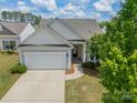 View of the home featuring a two-car garage, front door, landscaped yard and mature tree at 3043 Santee Ct, Fort Mill, SC 29707