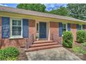 Close-up of the brick home's entrance with blue shutters and a matching blue front door at 3901 Kitley Pl, Charlotte, NC 28210