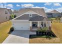 Inviting one-story home showing manicured lawn and a welcoming front porch at 4040 Deep River Way, Waxhaw, NC 28173