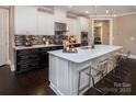 Large kitchen island with bar seating complements modern white cabinets, quartz countertops, and black accents at 5059 Valita Rd, York, SC 29745