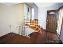 Inviting entryway features hardwood floors and staircase with white railings for a classic and clean look at 5127 Murrayhill Rd, Charlotte, NC 28210