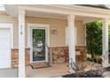 Inviting front porch with stone accents, a decorative wreath, and a cozy seating area at 516 Tribune Dr, Charlotte, NC 28214