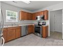 Efficient kitchen with stainless steel appliances, oak cabinets and tile flooring at 5312 Peach Place Ln, Charlotte, NC 28216