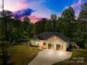 Aerial view of beautiful home nestled among lush trees with extended driveway at 5615 American Way, Denver, NC 28037