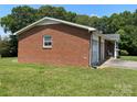 Angled view of the brick home featuring an attached two-car garage, and a covered front porch at 675 E Ritchie Rd, Salisbury, NC 28146