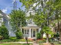 Two-story home with a cozy front porch, green lawn and mature landscaping at 6909 Dunton St, Huntersville, NC 28078