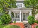 Inviting front porch features classic white columns and offers a relaxing entry at 6909 Dunton St, Huntersville, NC 28078