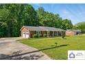 A brick home with an attached two-car garage and a long driveway, surrounded by mature trees at 707 Hester Dr, Dallas, NC 28034