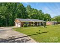 Well-maintained brick home with attached garage, beautiful lawn, and mature trees at 707 Hester Dr, Dallas, NC 28034