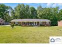 Well-maintained brick home with a green lawn, complemented by neat landscaping and a covered entrance at 707 Hester Dr, Dallas, NC 28034