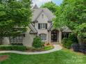 Charming brick home featuring a manicured lawn, mature trees, and elegant landscaping at 7138 Wessynton Dr, Charlotte, NC 28226