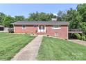 Charming brick home with a well-manicured lawn, walkway, and covered parking on a sunny day at 805 Waverly Pl # 16, Statesville, NC 28677