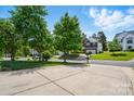 Peaceful street view featuring well-maintained homes with mature trees and long driveways at 8833 Cavonnier Ln, Charlotte, NC 28216
