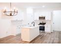 Modern kitchen features white cabinets, stainless steel appliances, an island with sink and wood floors at Lot 1 New Pineola Rd, Charlotte, NC 28208