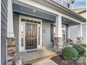 Charming front door with sidelights and transom window, complemented by stone accents and a welcoming porch at 1026 Slew O Gold Ln, Indian Trail, NC 28079
