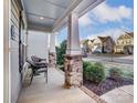 Inviting front porch featuring stone pillars, seating area, and well-maintained landscaping at 1026 Slew O Gold Ln, Indian Trail, NC 28079